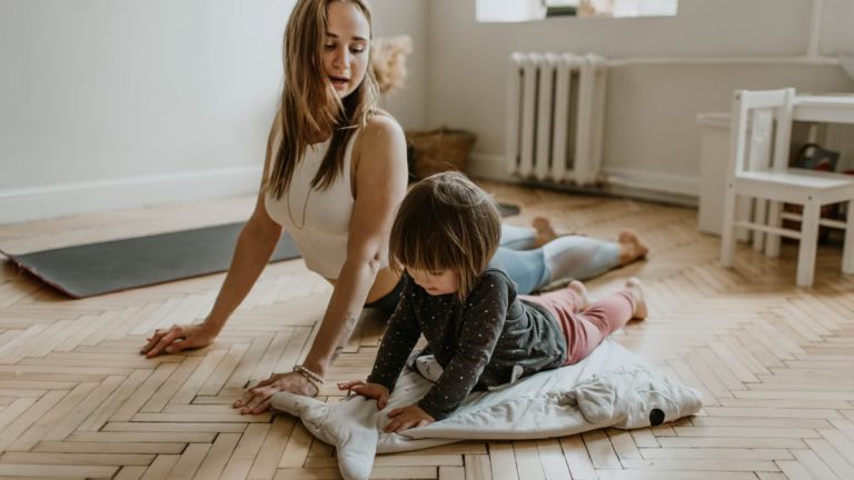 A mother and child practicing yoga together at home on a sunny day, fostering wellness and connection.