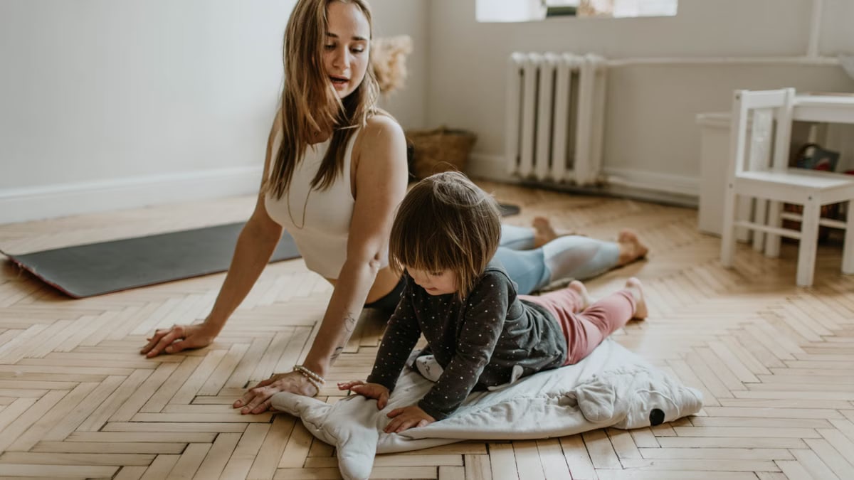 A mother and child practicing yoga together at home on a sunny day, fostering wellness and connection.