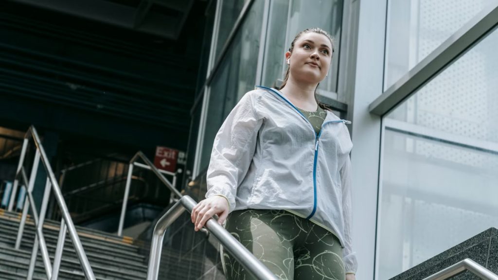 Active woman in sportswear walking down stairs, capturing a moment of motivation.
